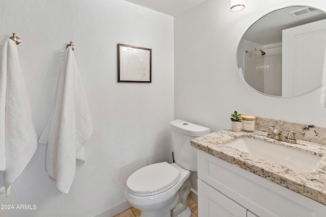 bathroom featuring tile patterned flooring, vanity, and toilet