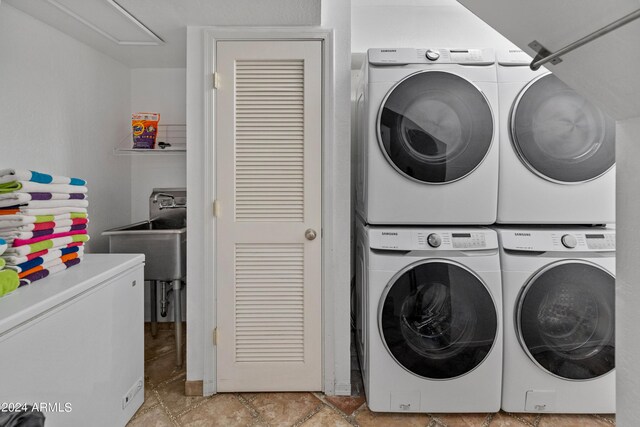 washroom featuring sink, stacked washer / drying machine, and washing machine and clothes dryer