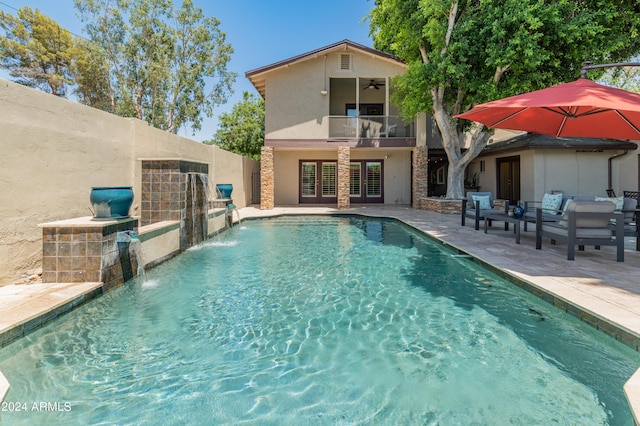 view of swimming pool with outdoor lounge area, pool water feature, ceiling fan, and a patio