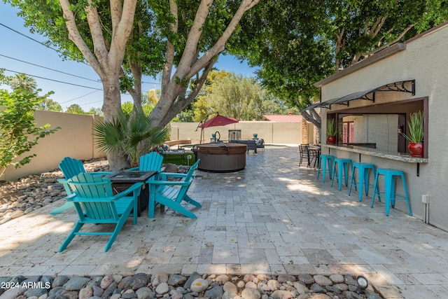 view of patio / terrace with a fire pit, an outdoor bar, and a hot tub