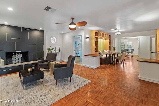 living room featuring ceiling fan and parquet floors