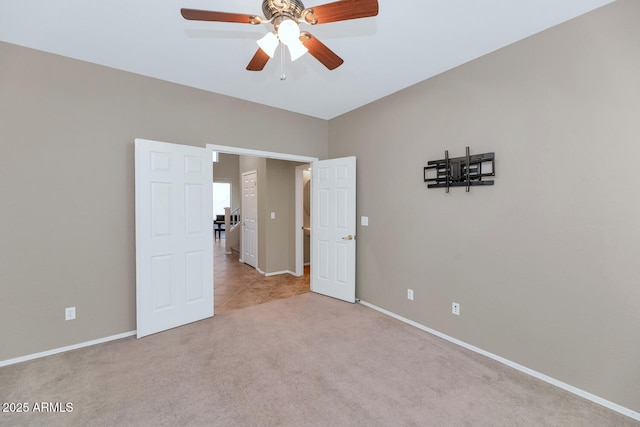 spare room featuring light carpet and ceiling fan