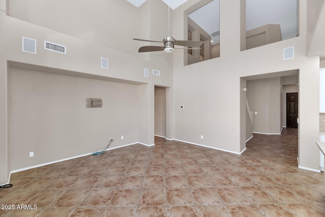 spare room featuring ceiling fan and a towering ceiling