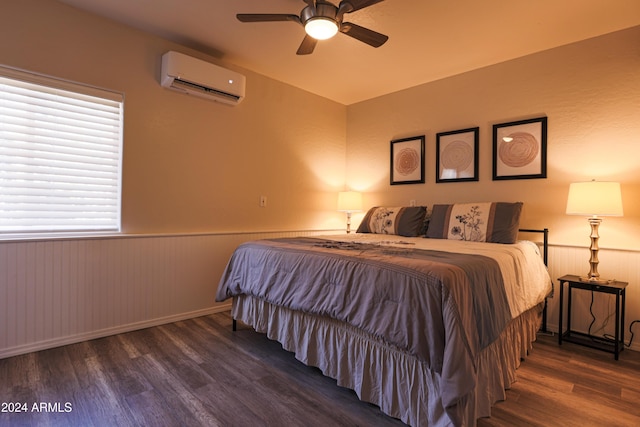 bedroom with dark hardwood / wood-style floors, ceiling fan, and a wall unit AC