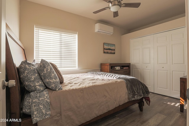 bedroom with a closet, dark hardwood / wood-style floors, a wall mounted AC, and ceiling fan