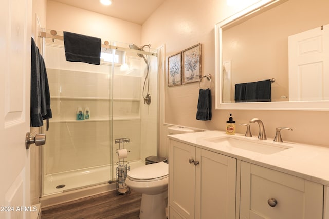 bathroom featuring a shower with shower door, toilet, wood-type flooring, and vanity