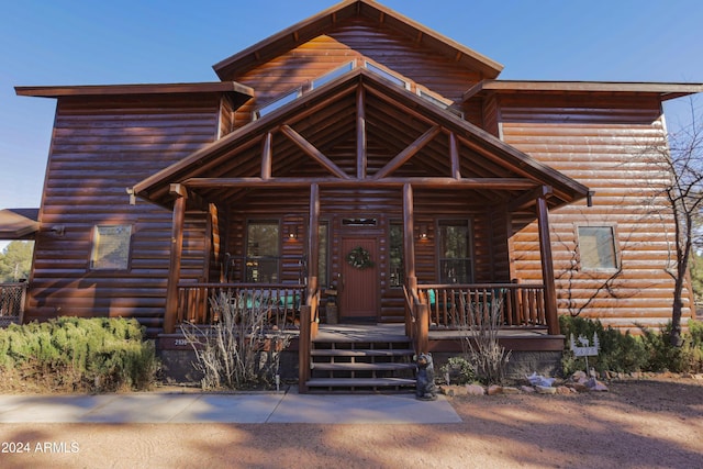 log cabin featuring covered porch