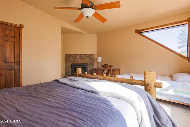 bedroom featuring carpet flooring, ceiling fan, a fireplace, and lofted ceiling