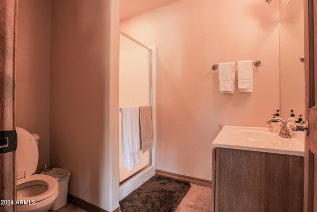 bathroom featuring vanity, toilet, and a shower with door