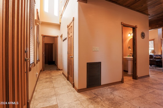 corridor with plenty of natural light, light tile patterned floors, and wooden ceiling