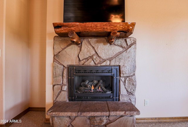 room details featuring carpet floors and a stone fireplace