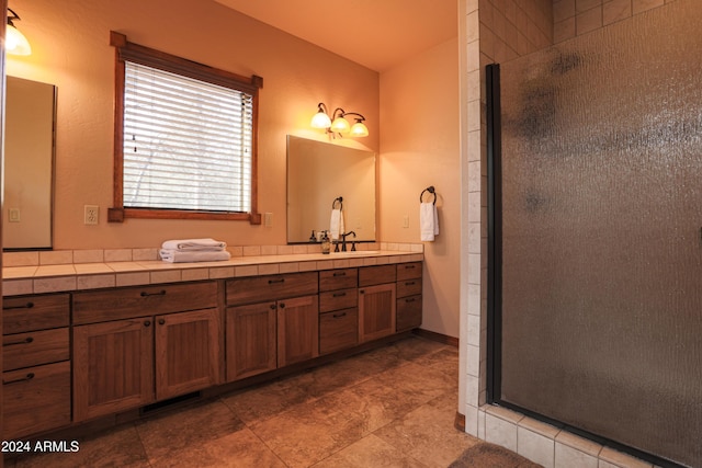 bathroom with a shower with door and vanity