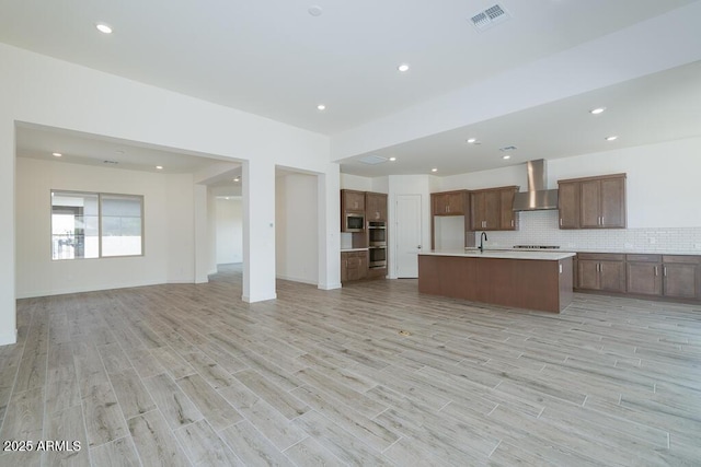 9775 S 36th Ln, Laveen, AZ 85339 - kitchen with open floor plan, wall chimney exhaust hood, a sink, light countertops, and light wood-style floors