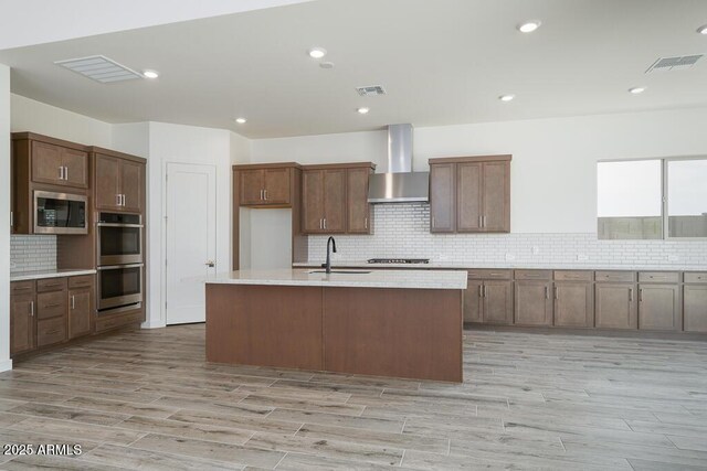 9775 S 36th Ln, Laveen, AZ 85339 - kitchen with wall chimney exhaust hood, stainless steel appliances, a sink, tasteful backsplash, and light countertops