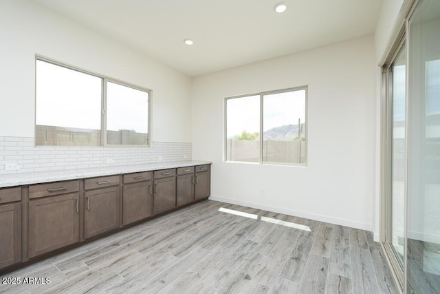 9775 S 36th Ln, Laveen, AZ 85339 - kitchen featuring tasteful backsplash, light wood-type flooring, recessed lighting, light stone counters, and baseboards