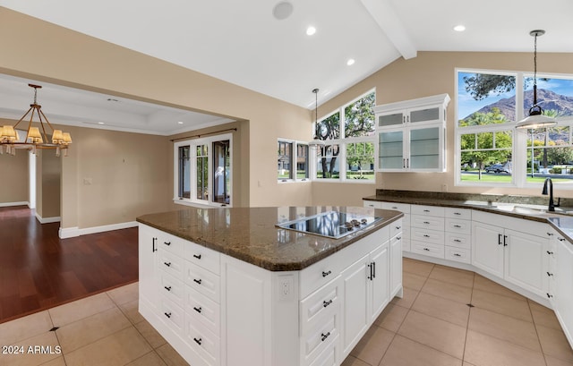 kitchen with black electric stovetop, a center island, plenty of natural light, and sink