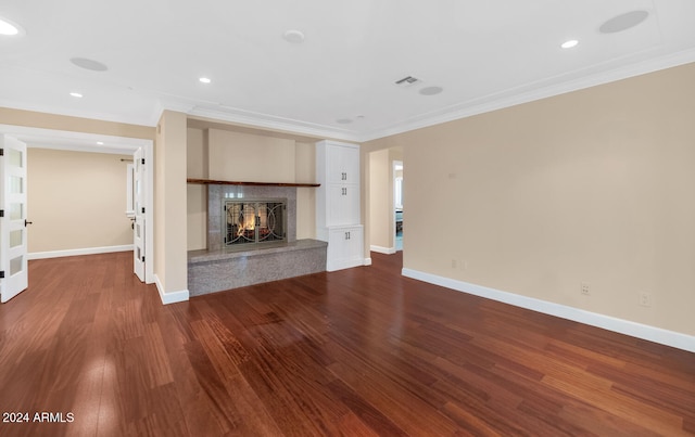 unfurnished living room featuring hardwood / wood-style flooring and crown molding