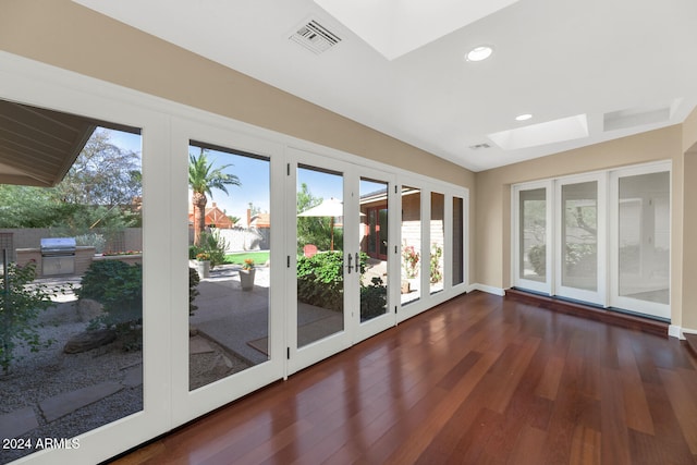 doorway with a skylight, dark hardwood / wood-style flooring, a healthy amount of sunlight, and french doors