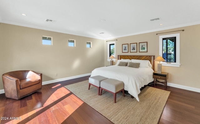 bedroom with dark hardwood / wood-style floors and ornamental molding