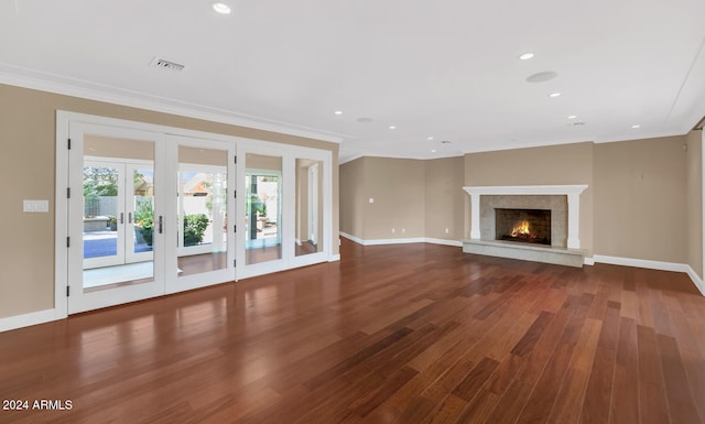 unfurnished living room featuring french doors, dark hardwood / wood-style flooring, and crown molding