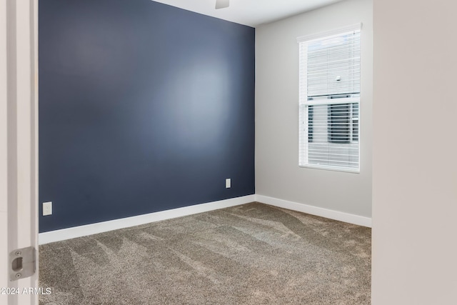 carpeted spare room with baseboards