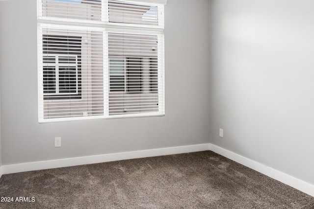 spare room featuring carpet floors and baseboards