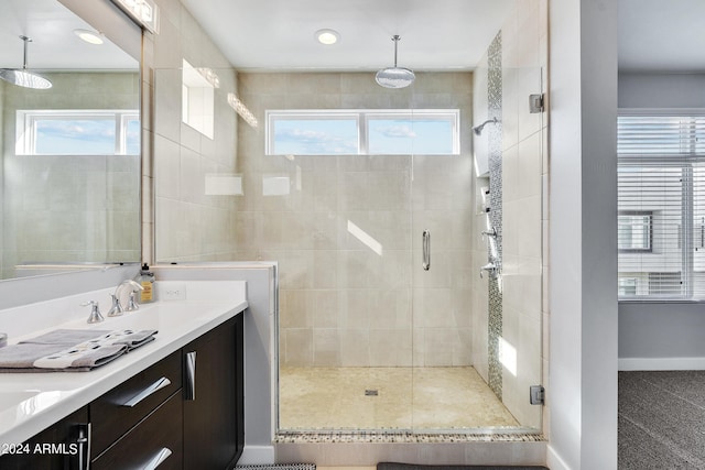 bathroom with a sink, a stall shower, and a wealth of natural light