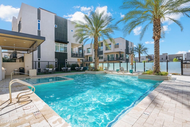 community pool with a residential view, fence, and a patio