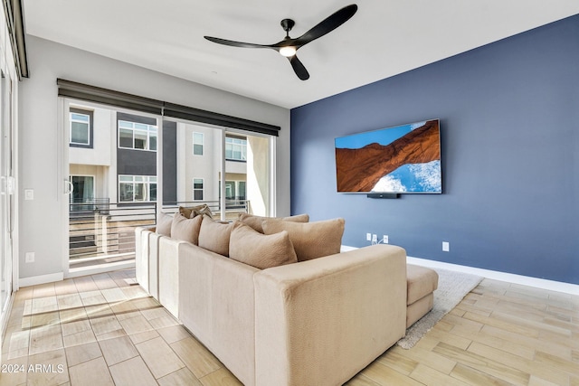 living room with light wood-style flooring, baseboards, and a ceiling fan