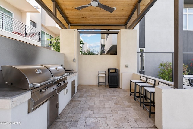 view of patio with outdoor wet bar, a grill, area for grilling, and a ceiling fan