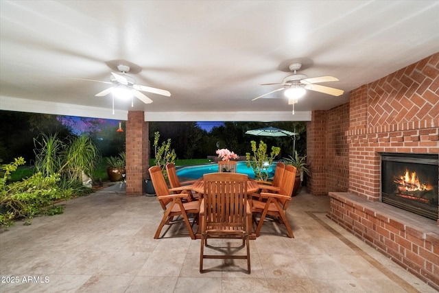 view of patio with an outdoor brick fireplace and ceiling fan