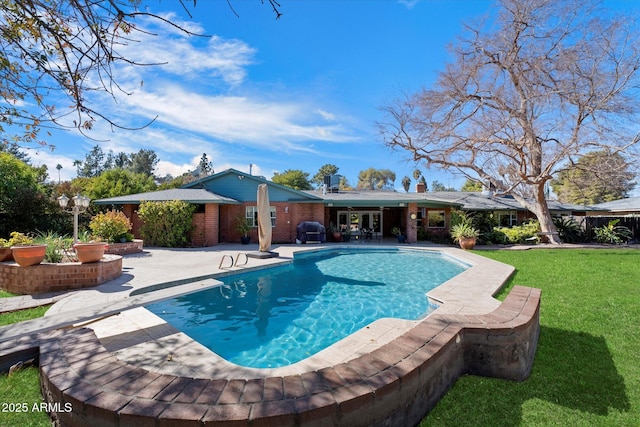 view of pool featuring area for grilling, a patio, a lawn, and a diving board