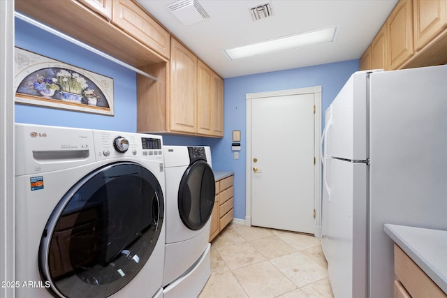 washroom with washer and dryer and light tile patterned floors