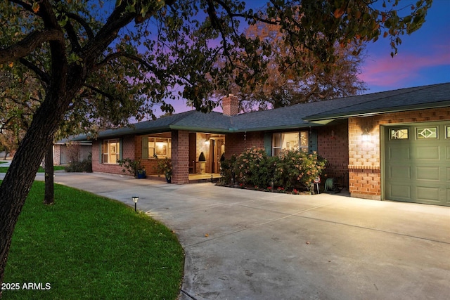 single story home featuring a garage and a lawn