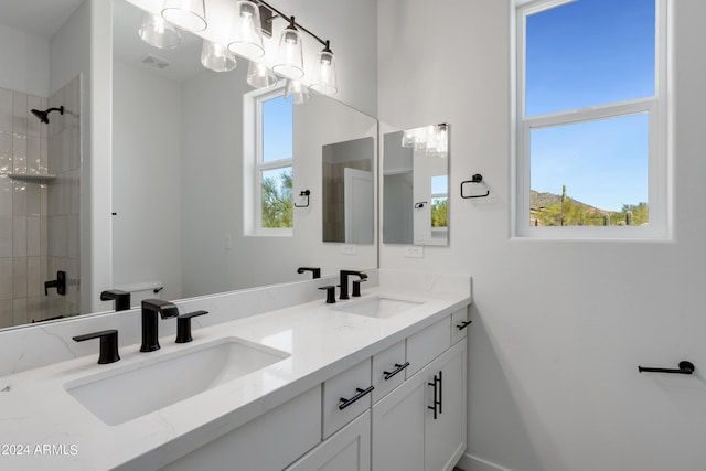 full bath with plenty of natural light, a tile shower, and a sink