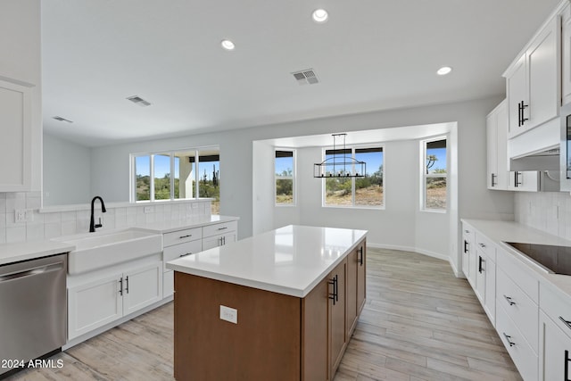 kitchen with light wood finished floors, visible vents, stainless steel dishwasher, a sink, and black electric cooktop