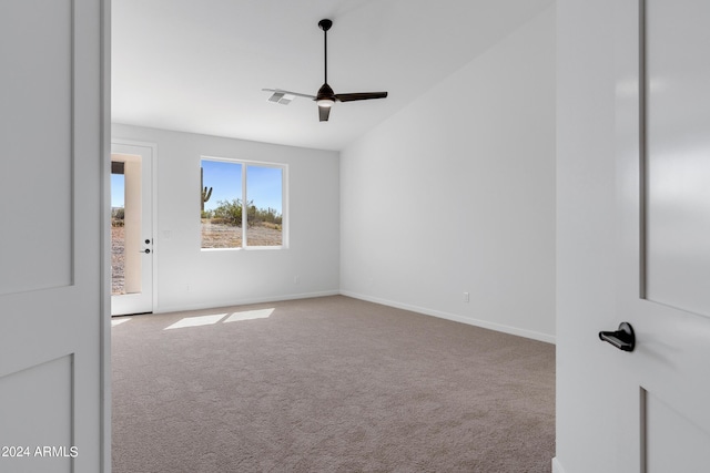 carpeted empty room with vaulted ceiling, a ceiling fan, and baseboards