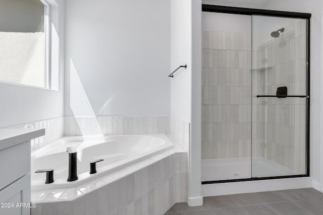 bathroom featuring a stall shower, tile patterned flooring, and a bath