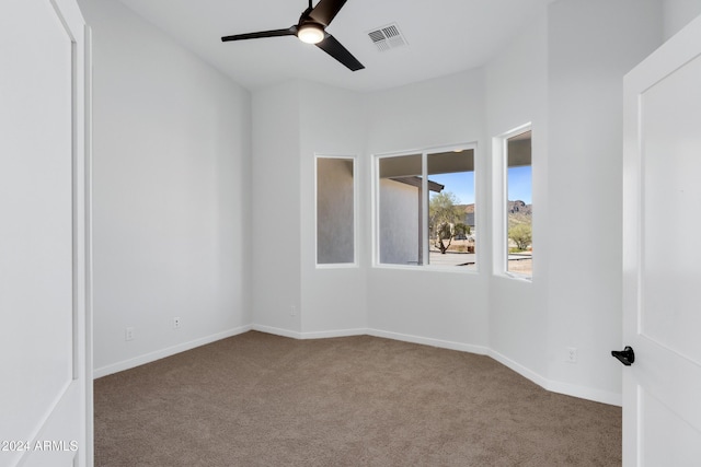 carpeted empty room with ceiling fan, visible vents, and baseboards