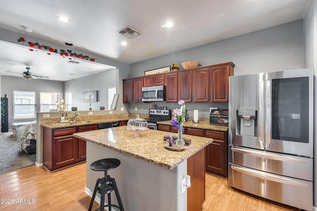 6328 W Fawn Dr, Laveen, AZ 85339 - kitchen featuring visible vents, light wood finished floors, a peninsula, and stainless steel appliances