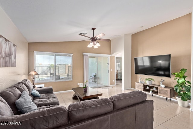 living area featuring light tile patterned floors, visible vents, arched walkways, ceiling fan, and vaulted ceiling