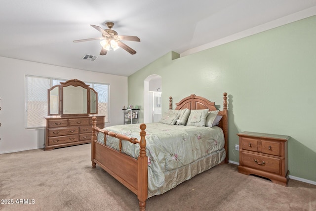 bedroom with ceiling fan, arched walkways, light carpet, visible vents, and baseboards