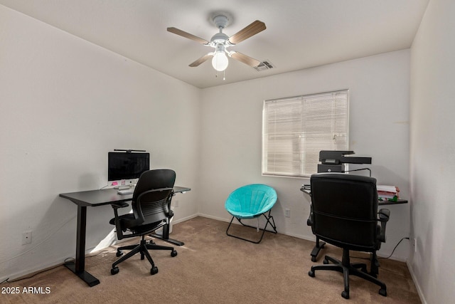 office space featuring light carpet, ceiling fan, visible vents, and baseboards