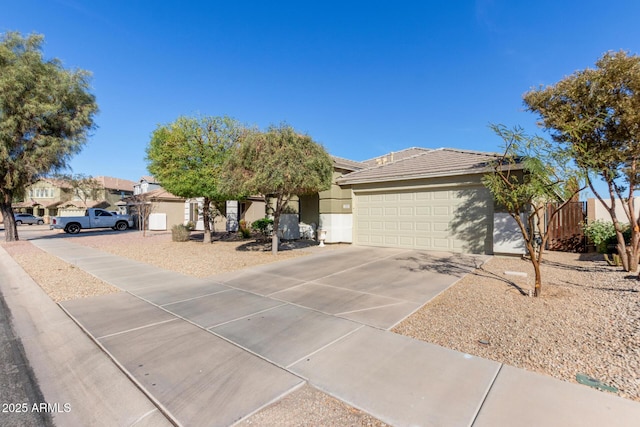 view of front of property with concrete driveway, a tiled roof, an attached garage, and stucco siding