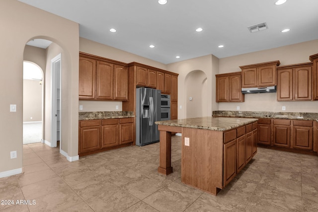 kitchen featuring light stone countertops, appliances with stainless steel finishes, and a kitchen island