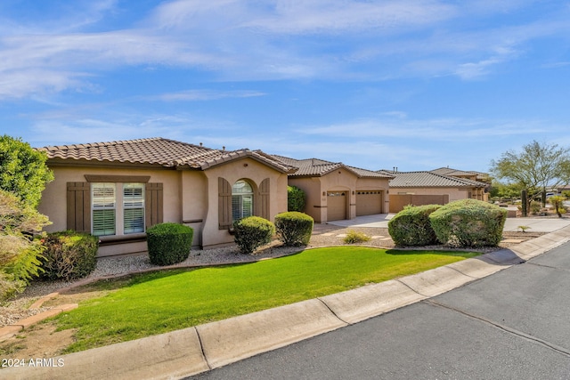 mediterranean / spanish-style home with a garage and a front lawn