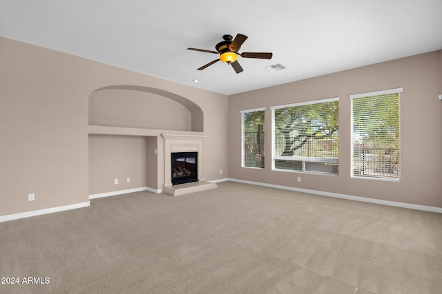 unfurnished living room featuring light carpet and ceiling fan