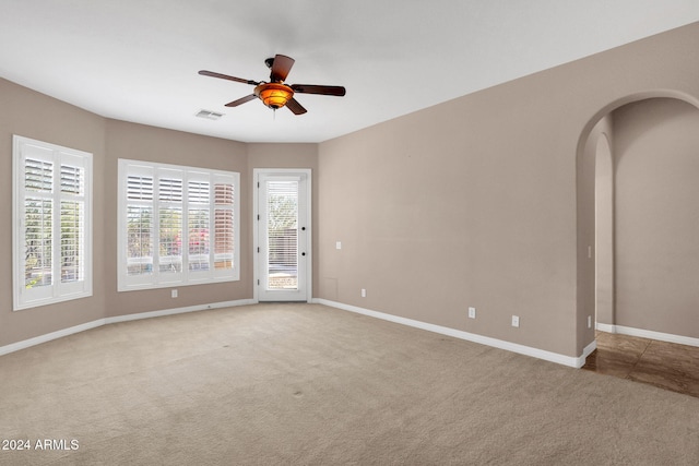 carpeted spare room featuring ceiling fan