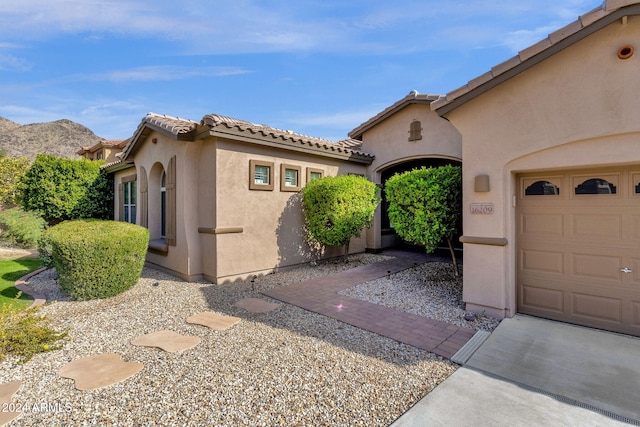 view of property exterior with a mountain view and a garage