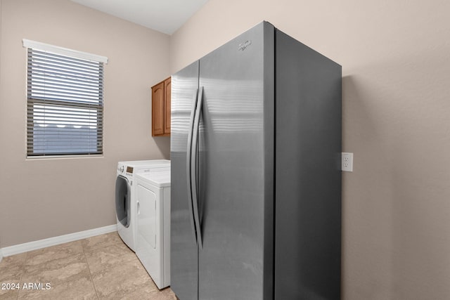 laundry area featuring cabinets, independent washer and dryer, and light tile patterned floors